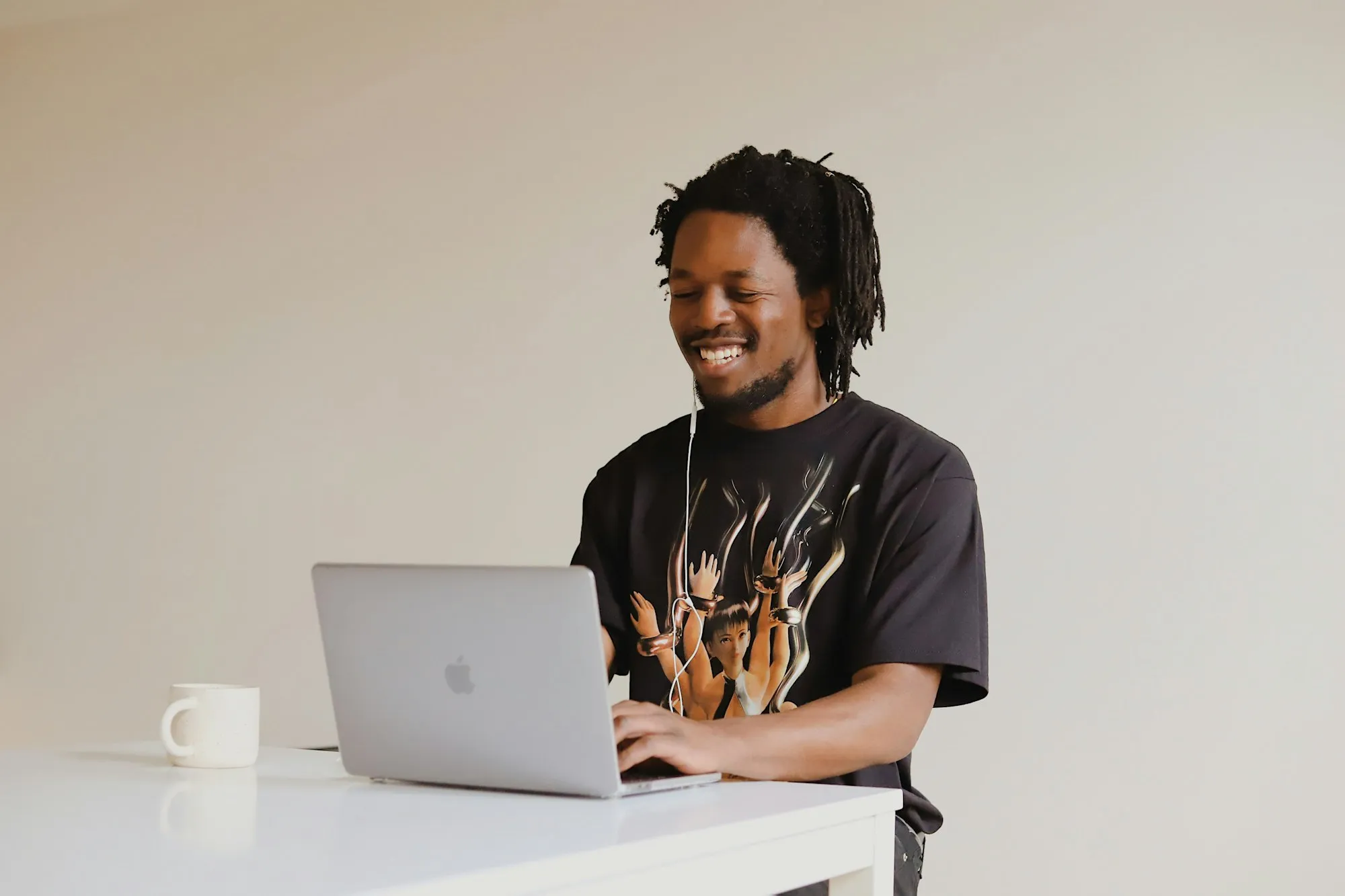 A developer smiling at a laptop in a bright office